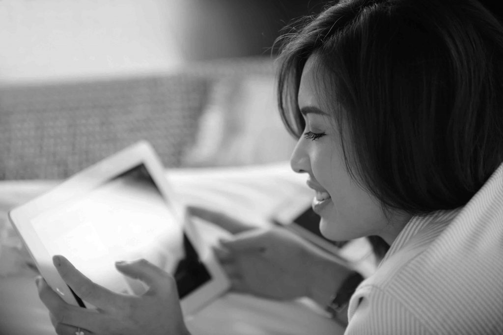 A woman navigating online on her tablet